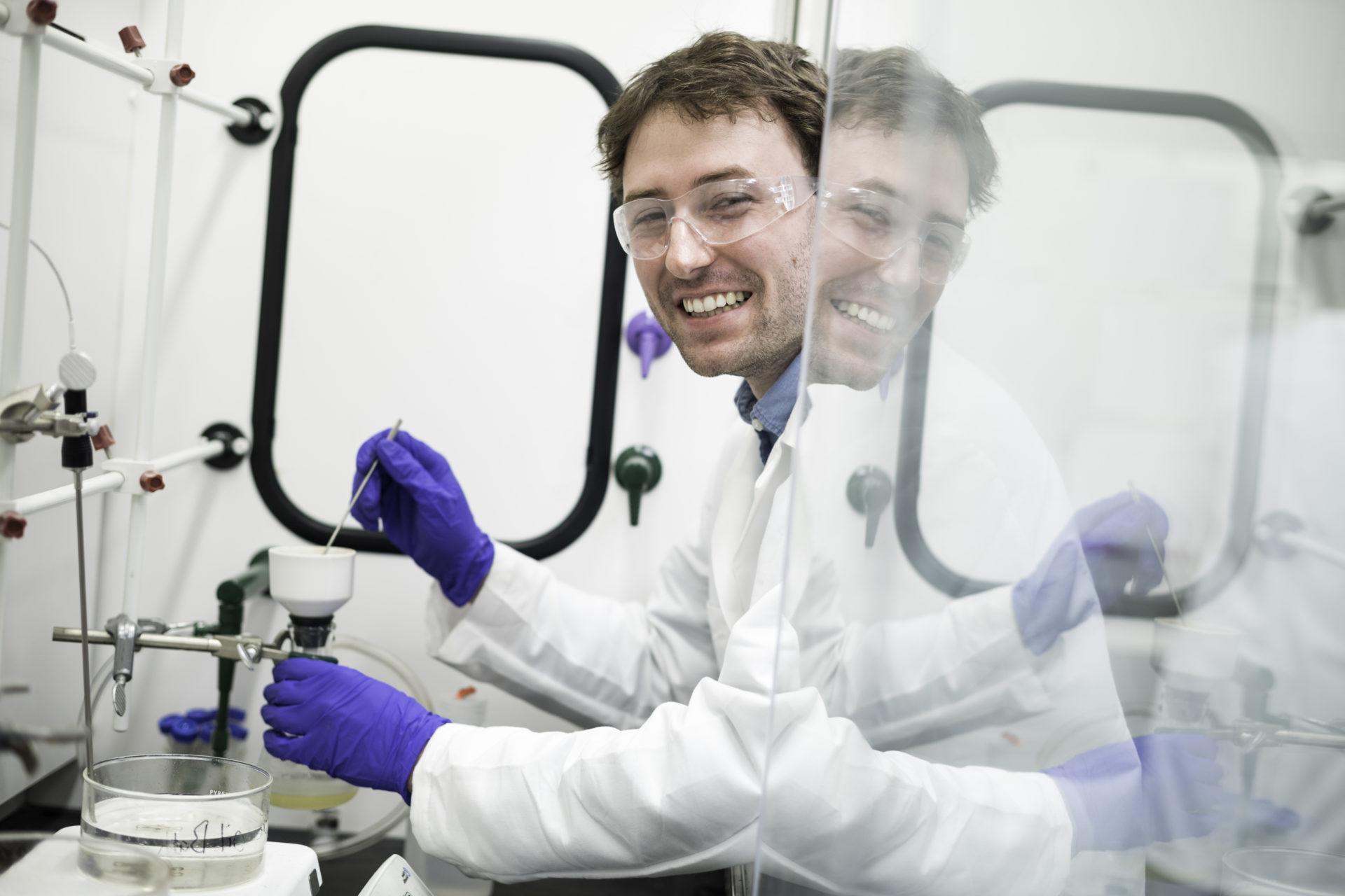 University of Rochester student in a laboratory wearing goggles and gloves